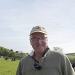Peter Wood auf der Weide mit seinen Kühen im Hintergrund