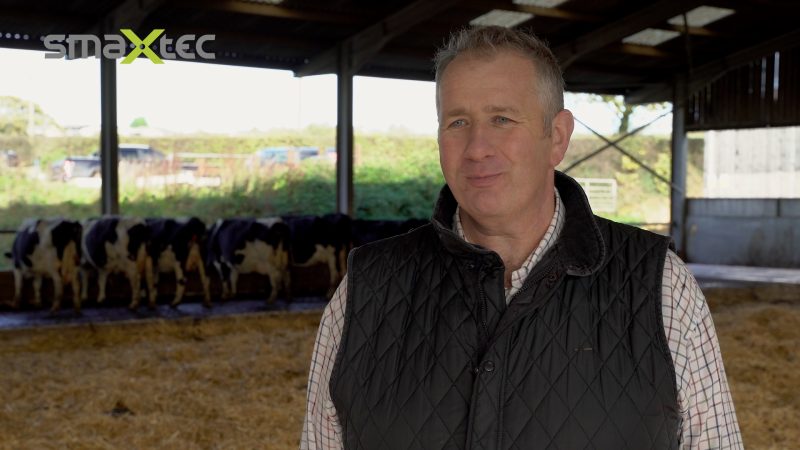 smaXtec testimonial Bill Jewell in his cowshed with his Holstein cows in the background
