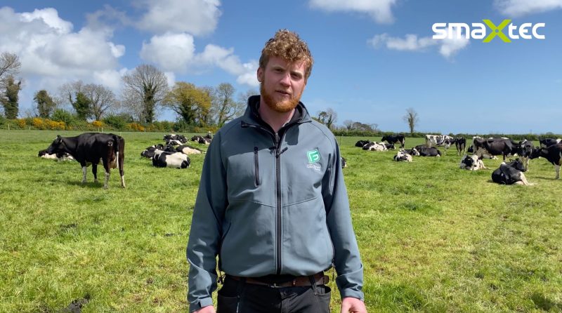 smaXtec testimonial Joe Gardiner in the pasture with his cows in the background